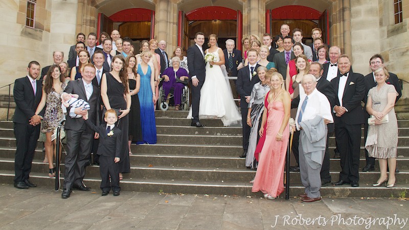 Couple with all their guests on the church steps - wedding photography sydney